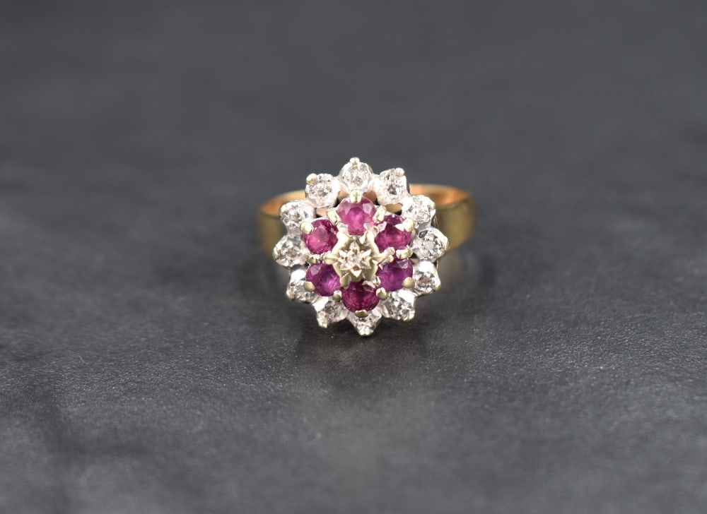 A diamond and ruby cluster ring, the central illusion set diamond with a six ruby surround having (1 of 4)