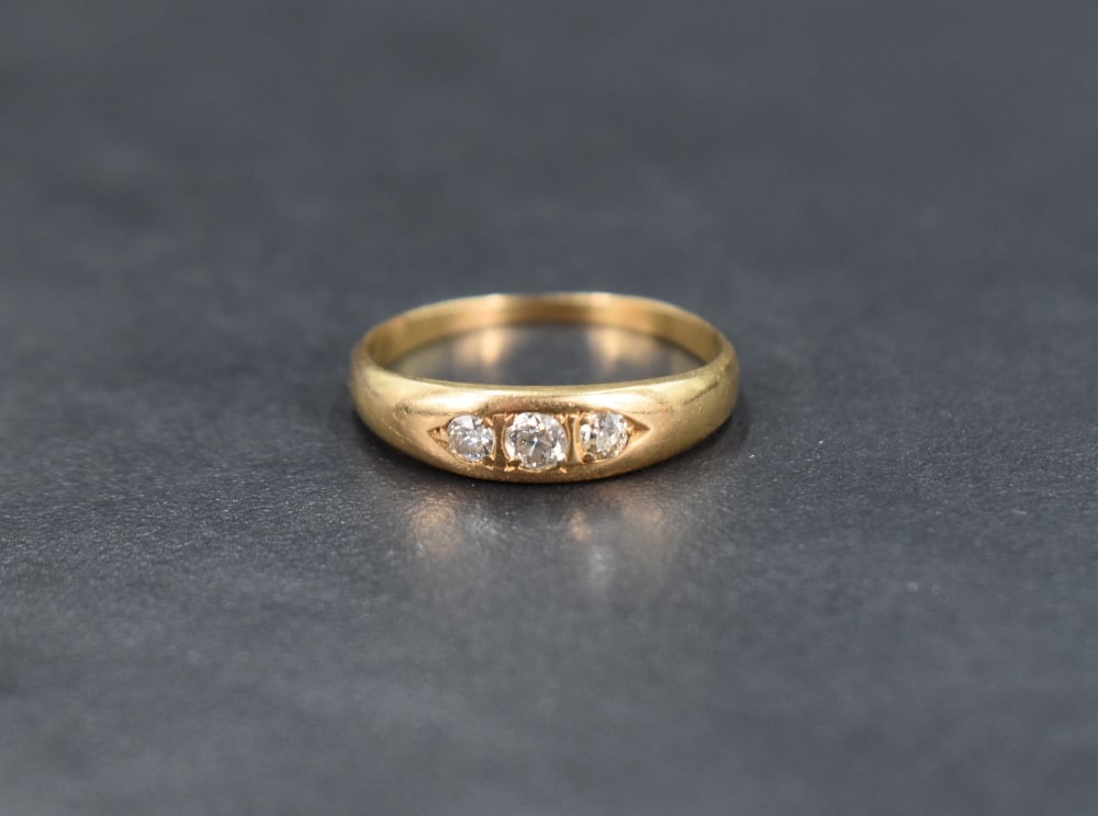 A three stone gypsy style diamond ring, the central diamond measuring approximately 0.07ct flanked (1 of 4)