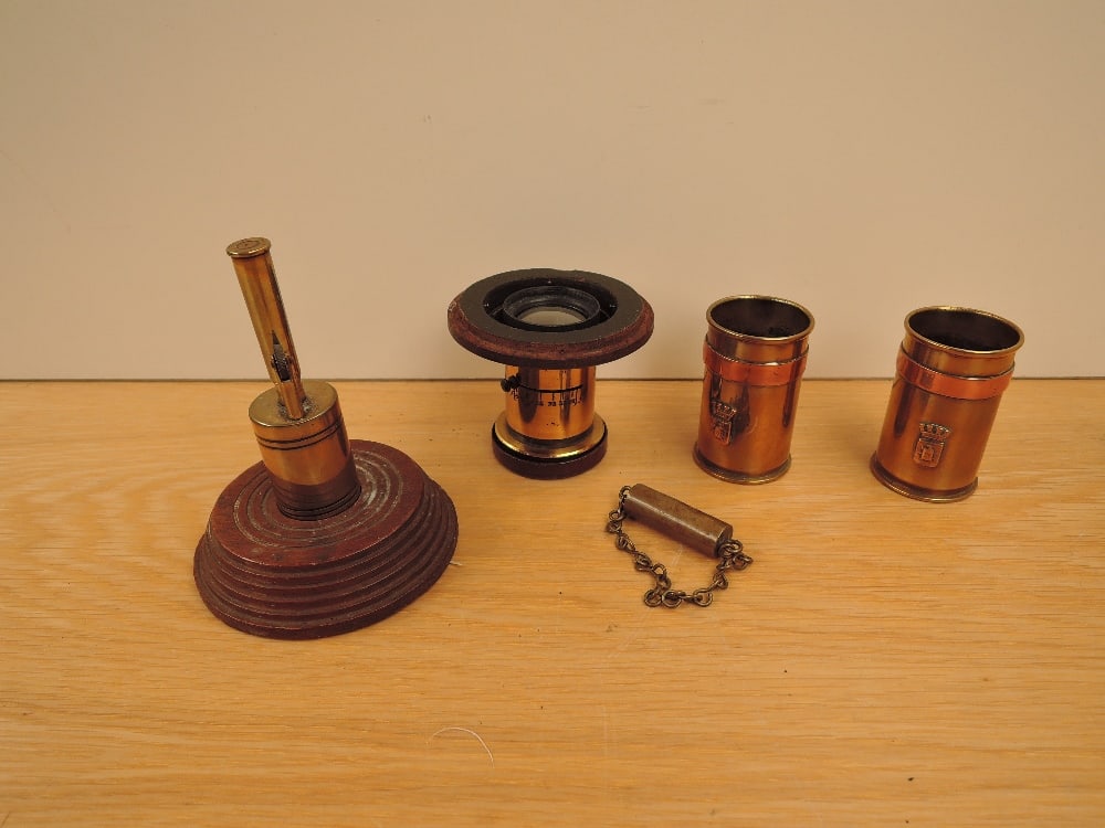 Five pieces of Trench Art, pair of Shell Vases dated 1917 & 1918 with Military Badges, a Shell: Five pieces of Trench Art, pair of Shell Vases dated 1917 & 1918 with Military Badges, a Shell case made into a lighter on wooden stand, a bullet made into a possible whistle and a possible shell