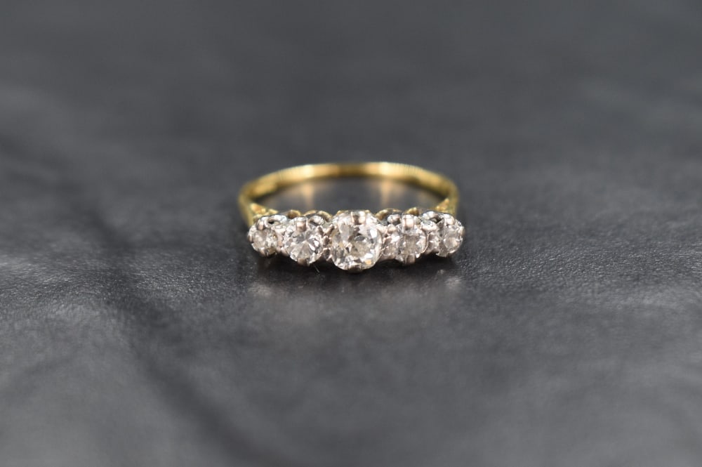 A five stone graduated diamond ring, total approx 1.25ct in a claw set raised mount on a yellow (1 of 3)