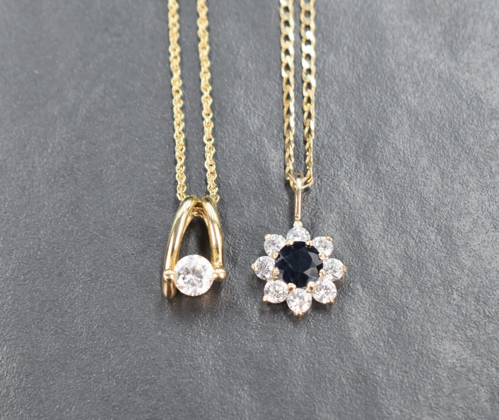 Two 9ct gold necklaces, comprising a modern cubic zirconia solitaire pendant on a 9ct rope chain,: Two 9ct gold necklaces, comprising a modern cubic zirconia solitaire pendant on a 9ct rope chain, and a sapphire and cubic zirconia cluster pendant on a 9ct curb link chain, 6.5g gross