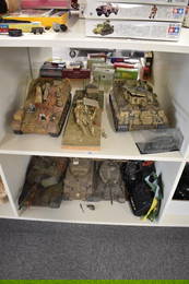 Two shelfs of plastic scale model kit built Military Tanks and Vehicles, some with remote