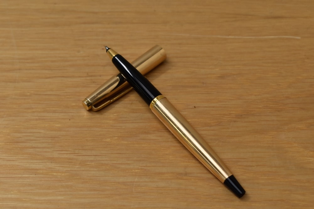 A Parker 45 Insignia CT rollerball pen in gold fill with black tassie: A Parker 45 Insignia CT rollerball pen in gold fill with black tassie