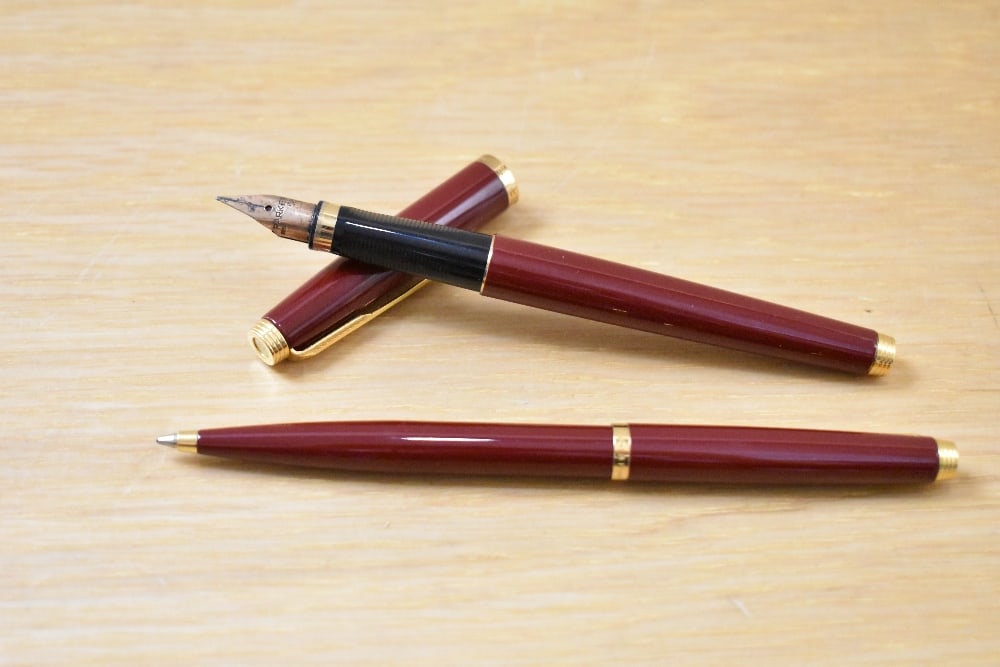 A Parker 75 cartridge/ converter fill fountain pen and ballpoint pen set in red having Parker 585: A Parker 75 cartridge/ converter fill fountain pen and ballpoint pen set in red having Parker 585 France nib