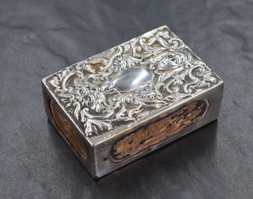 A Victorian silver match box holder, having embossed scroll work and depictions of the Green Man, (1 of 3)