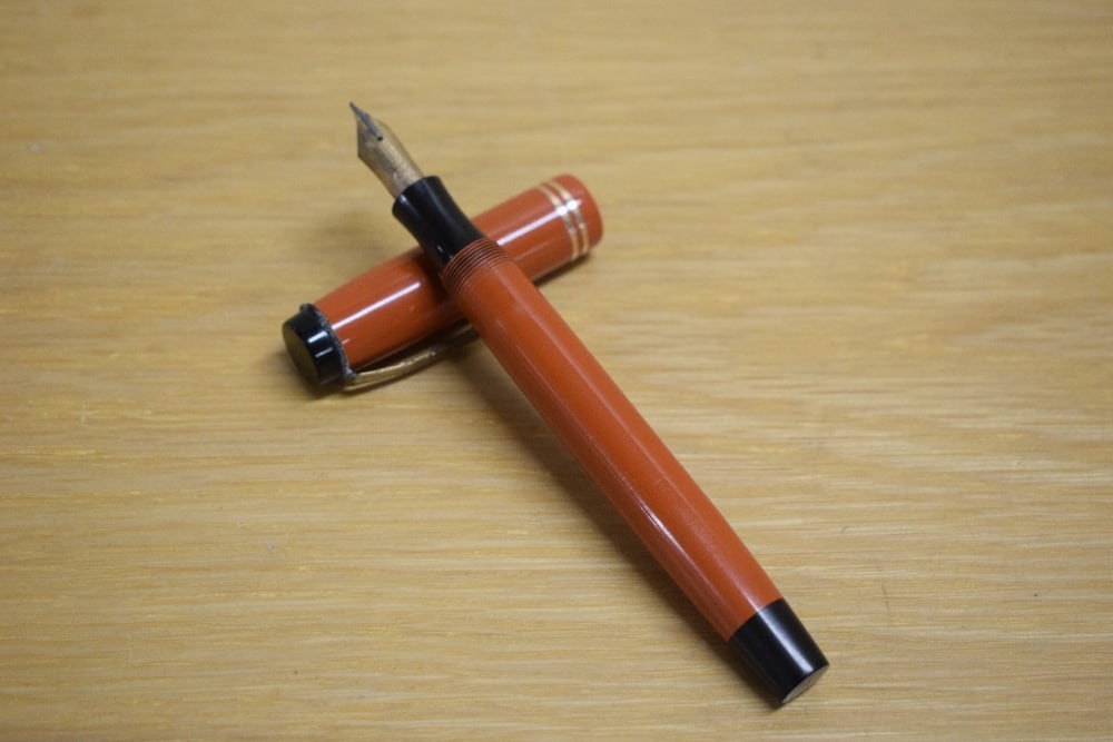 A Parker Duofold Senior button fill fountain pen in orange with two gold bands to the cap having 14K (1 of 3)