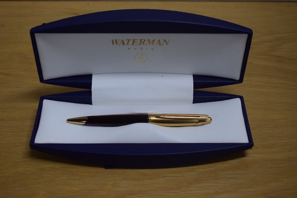 A boxed Waterman Edson ballpoint pen in ruby red with gold cap. Booklet and refill in box. Slight (1 of 2)