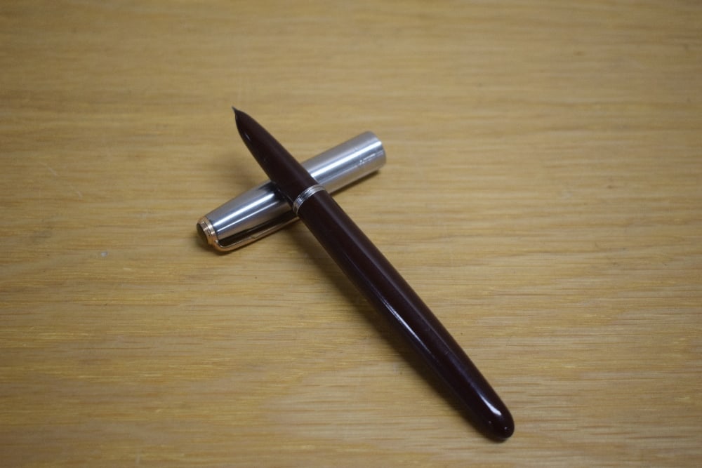 A Parker 51 vacumatic fill fountain pen in Cordovan Brown with lustraloy cap with jewellers band and: A Parker 51 vacumatic fill fountain pen in Cordovan Brown with lustraloy cap with jewellers band and gold fill blue diamond clip