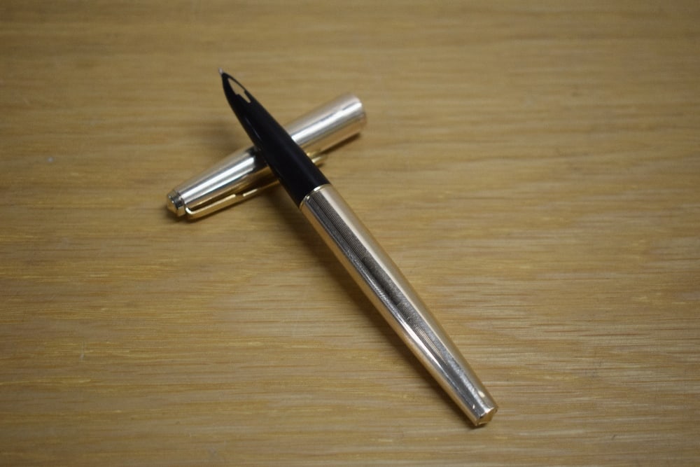 A Parker 61 Insignia converter fill fountain pen in gold plate: A Parker 61 Insignia converter fill fountain pen in gold plate