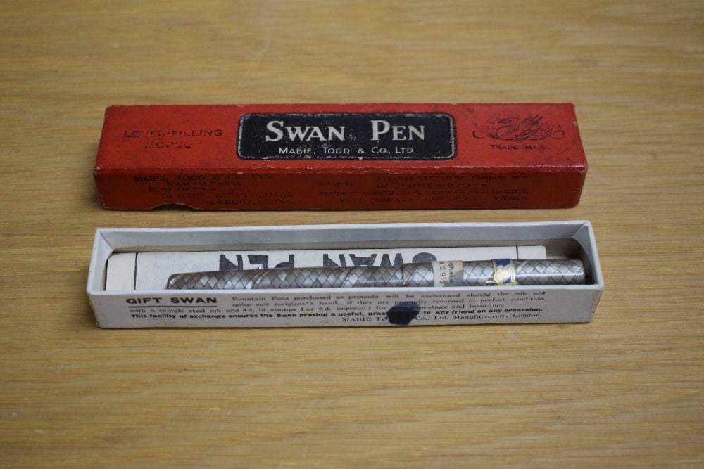 A boxed Mabie Todd & Co Swan self filler lever fill fountain in grey and ruby snakeskin having: A boxed Mabie Todd & Co Swan self filler lever fill fountain in grey and ruby snakeskin having Swan 2 14CT nib. Still bearing labels