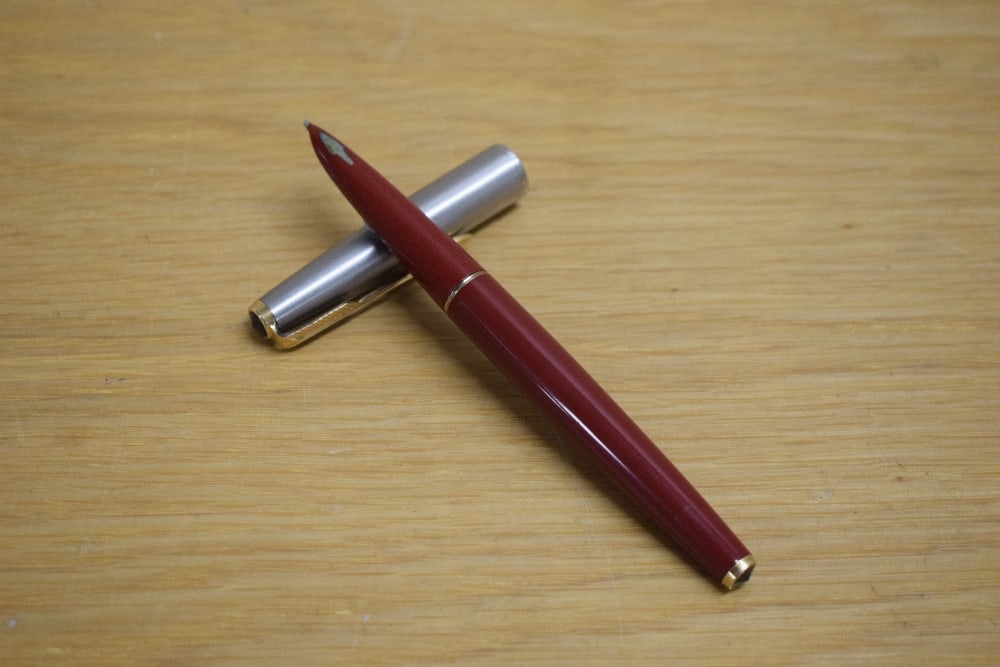 A Parker 61 capillary fill fountain pen in rage red with lustraloy cap with gold trim: A Parker 61 capillary fill fountain pen in rage red with lustraloy cap with gold trim