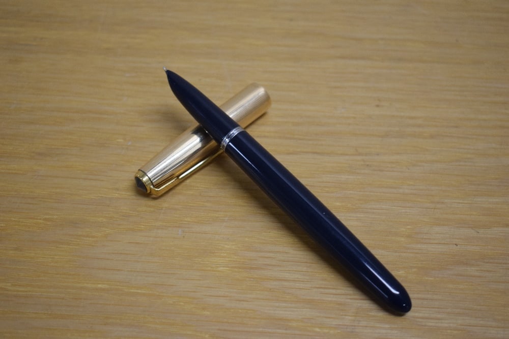 A Parker 51 MKII aerometric fill fountain pen in navy blue with rolled gold cap.: A Parker 51 MKII aerometric fill fountain pen in navy blue with rolled gold cap.