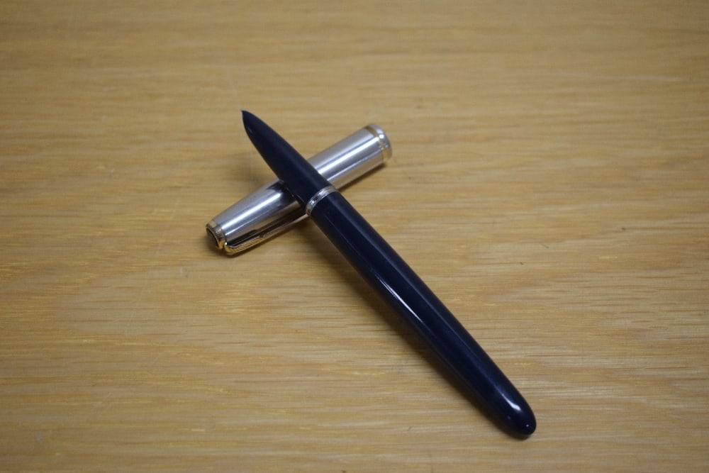 A Parker 51 MKII aerometric fill fountain pen in navy blue with flighter cap with single gold cap: A Parker 51 MKII aerometric fill fountain pen in navy blue with flighter cap with single gold cap band and trim. Slight wear to cap band