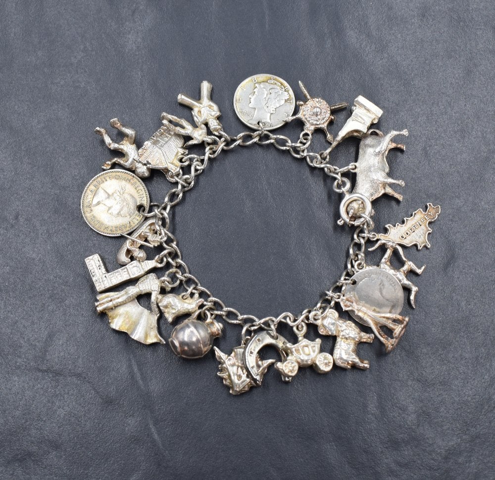 A white metal charm bracelet, having twenty-two charms including a bull, three coins, St. Edward's (1 of 1)