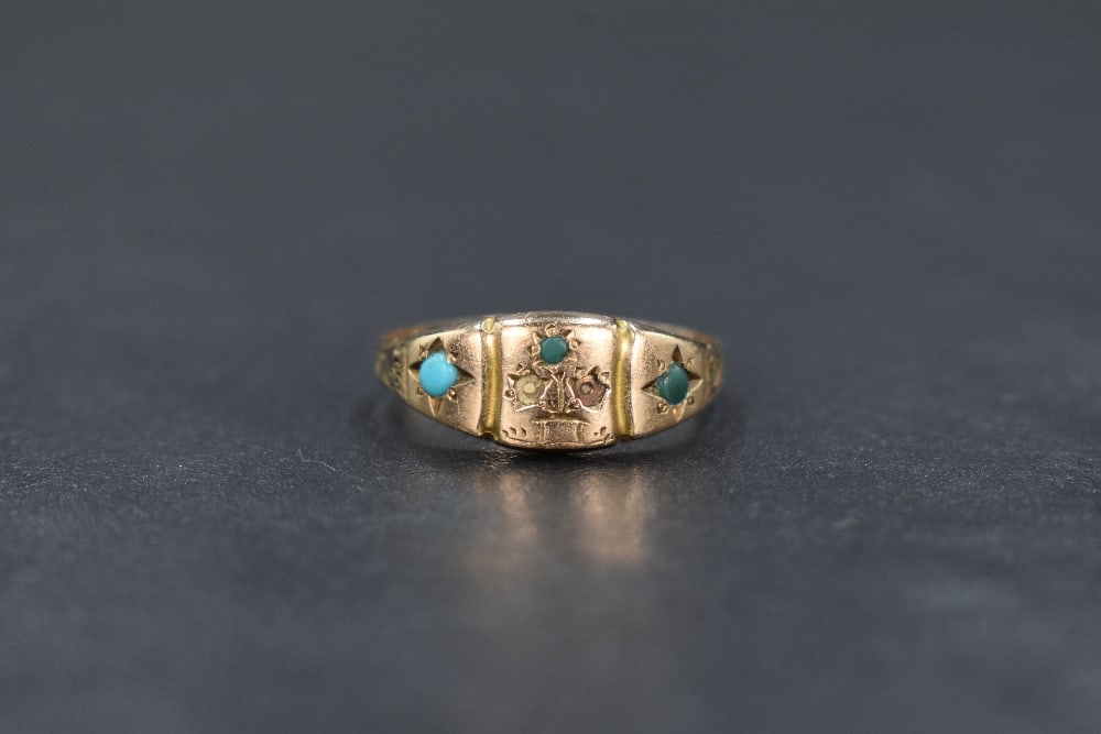 A 9ct gold turquoise gypsy style ring, the three central turquoise cabochons in a flower motif, (1 of 9)