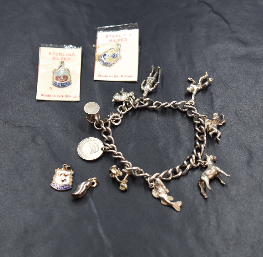 A silver charm bracelet, having nine white metal charms including a rabbit, a Norman soldier and a (1 of 1)