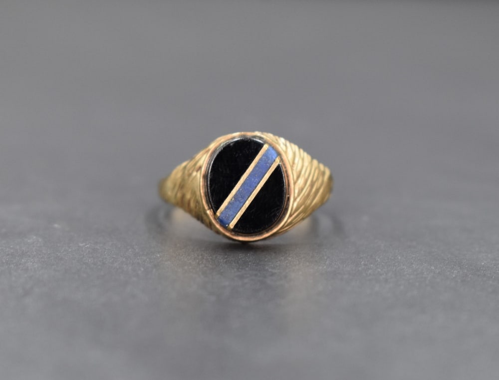 A 9ct gold signet ring, the oval onyx panel having a blue stone and gold diagonal inlay, with (1 of 4)