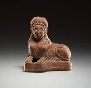 AN ALEXANDRIAN TERRACOTTA SPHINX: AN ALEXANDRIAN TERRACOTTA SPHINXRoman Egypt / 1st cent. B.C.–1st cent. A.D. / Clay, mould-made / H = 11.3 cm (4 29/64 in) Reclining sphinx with magnificent headdress, resting on its forelegs on a