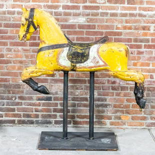 Yellow Painted American Carousel Horse on Stand: Circa 19th century antique yellow painted American carousel horse on stand detailed with a saddle and bridle. The horse is further ornamented with a shield shaped coat of arms on the sides and front