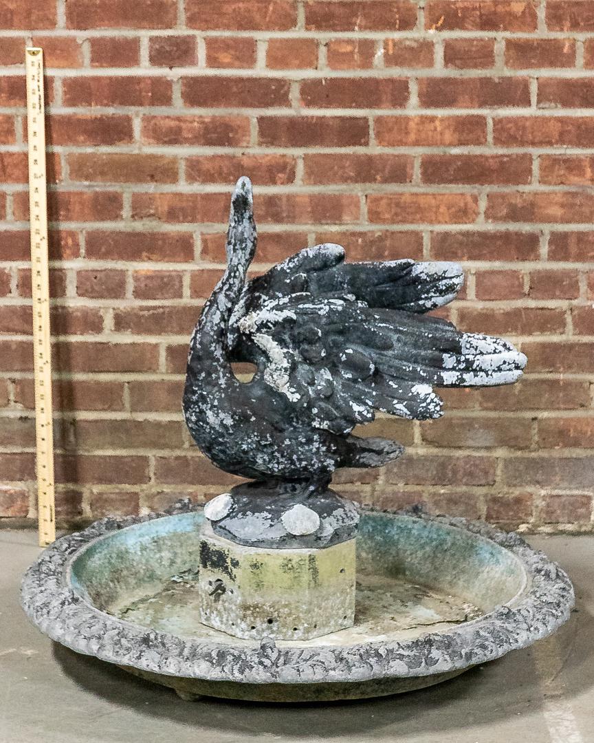 Lead Fountain with Finial of Swan in Flight: Lead single basin water fountain with central finial statue of swan in flight. The statue is detailed with windswept feathers and elongated neck. Please note of wear consistent with age including pati