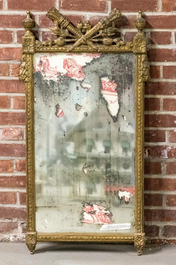 French Giltwood Mirror with Original Glass Plate: French giltwood mirror with original glass plate. The crown is ornamented with central motifs of flaming torches flanked by urn shaped finials. The mirror is also accented by rosettes on each corner a