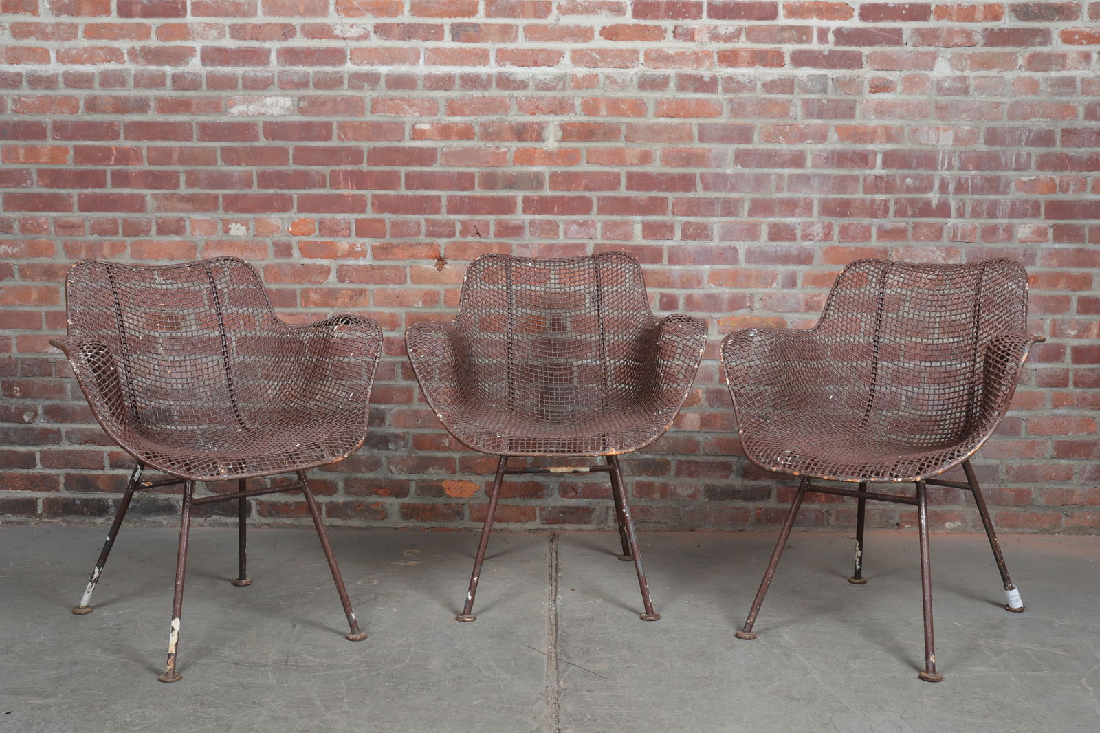 Set of Three Russell Woodard Sculptura Chairs: Grouping of three brown painted "Sculptura" chairs by Russell Woodard. Originally designed in the 1950s by one of the sons of Woodard Furniture Co, Russell, this enamel on wrought iron wire chair is a