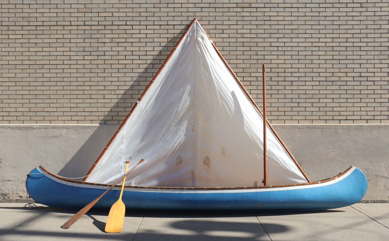 1940's Old Town Sailing Canoe: Vintage 1940's sailing canoe from Old Town Canoe Co. of Old Town, Maine. Blue with original orange paint revealed in parts below. Bent wood bracers, two rattan seats, two oars, and sail included. Cano