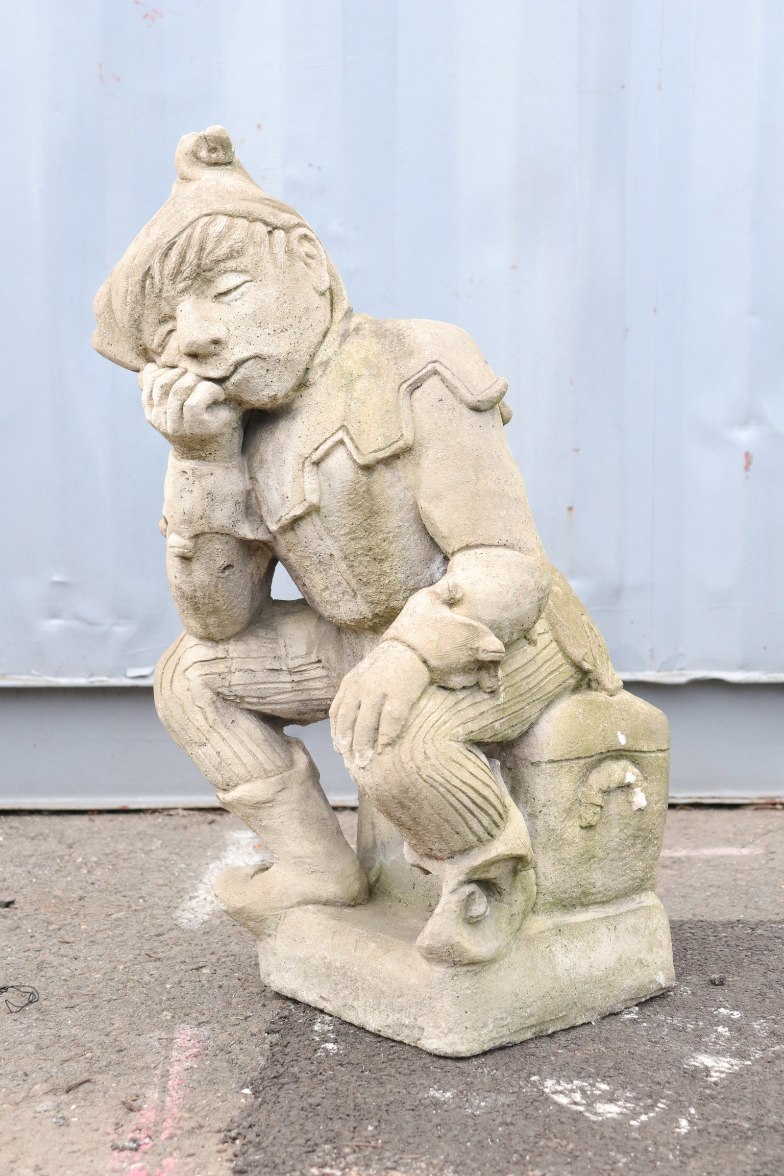 Stone Jester Statue: Stone jester statue on a square base.