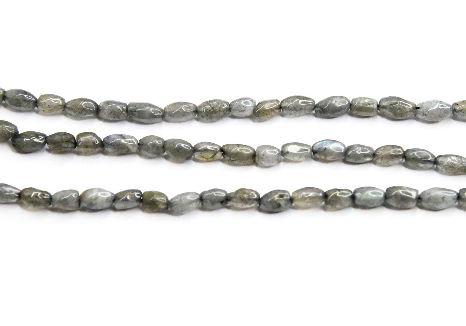 13.5" STRAND NATURAL LABRADORITE BEADS RICE 5X8 - 5X9 MM (3 LINES): These are natural, earth mined and hand crafted with precision. Stone: Labradorite, Stone Shape: Rice, Stone Size: 5x8 - 5x9 mm, Length: 13.5", Weight: approx. 76 carats. The photographs are enlarged