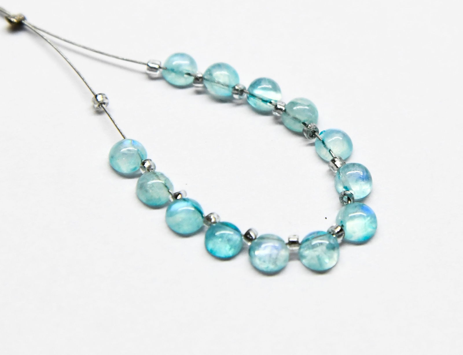 NATURAL RAINBOW MOONSTONE BEADS (COATED) FLATBACK ROUND 3.5 - 4 MM 13 PCS (3 TASSELS): These are natural, earth mined and hand crafted with precision. Stone: Rainbow Moonstone (Coated), Stone Shape: Flatback Round, Stone Size: 3.5 - 4 mm, Width: 2 - 2.5 mm, Weight: approx. 3.42 carats.