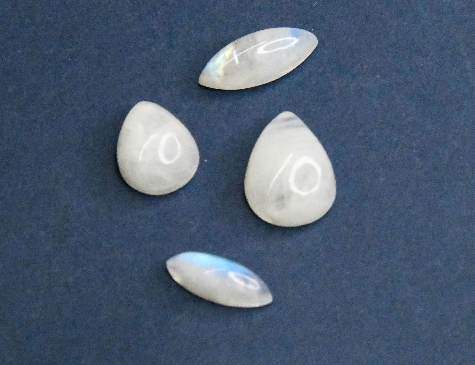 NATURAL RAINBOW MOONSTONE CABOCHONS PEAR, MARQUISE 6X16 - 13X17 MM 4 PCS: These are natural, earth mined and hand crafted with precision. Stone: Rainbow Moonstone, Stone Shape: Pear/Marquise, Stone Size: 13x17 mm, Width: 6 - 6.5 mm, Weight: approx. 29 carats. The photograph