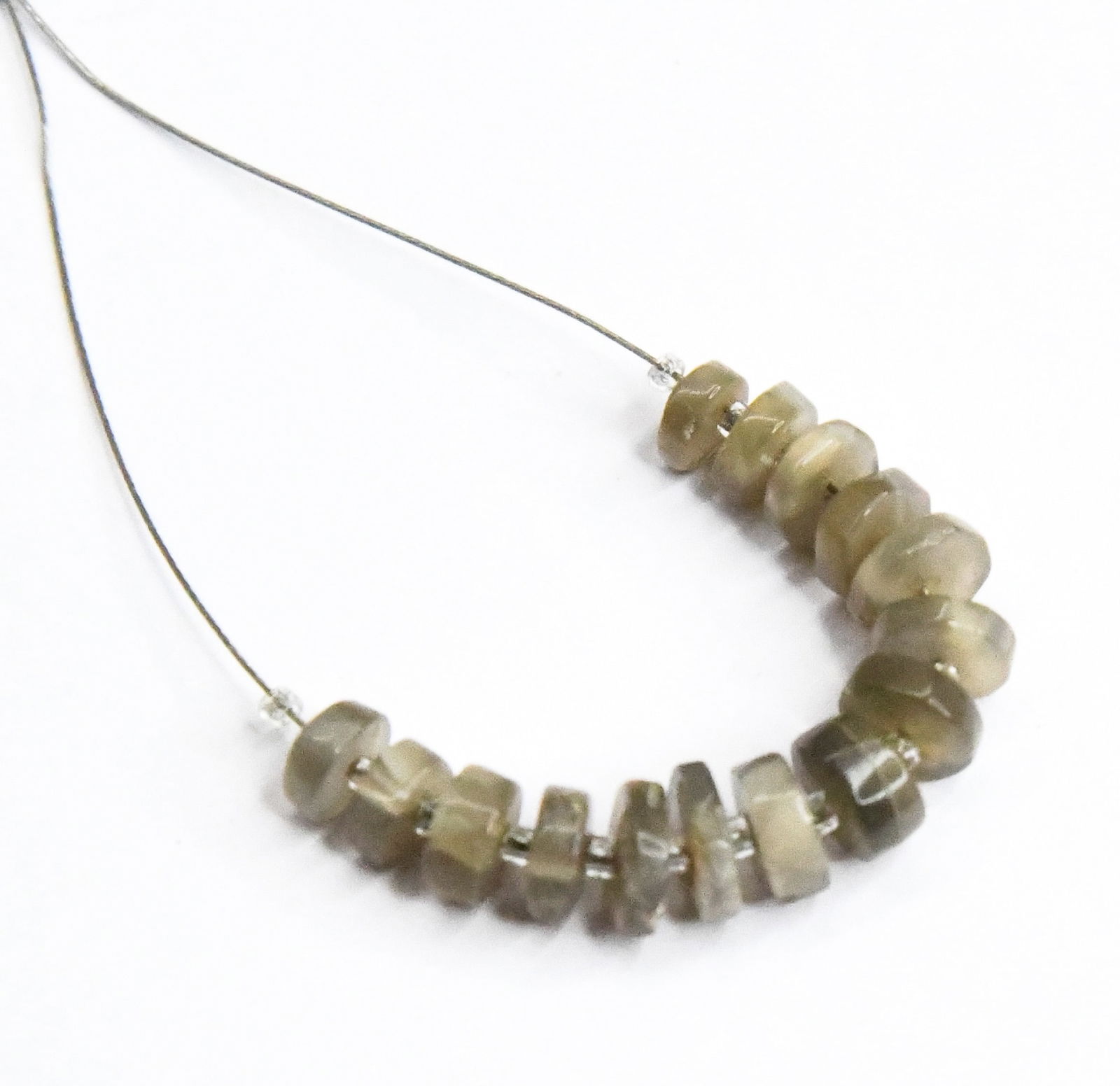 NATURAL GREY MOONSTONE BEADS TYRE 4 - 6 MM 15 PCS (5 TASSELS): These are natural, earth mined and hand crafted with precision. Stone: Moonstone, Stone Shape: Tyre, Stone Size: 4 - 6 mm, Width: 1.5 - 2.5 mm, Weight: approx. 8 carats. The photographs are enlarged t