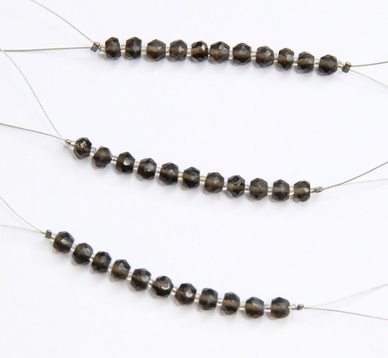 NATURAL SMOKY QUARTZ BEADS FACETED RONDELLE 4 - 4.5 MM, 11 PCS (3 TASSELS): These are natural, earth mined and hand crafted with precision. Stone: Smoky Quartz, Stone Shape: Faceted Rondelle, Stone Size: 4 - 4.5 mm, Width: 2 - 3.5 mm, Weight: approx. 5.50 cts. The photographs