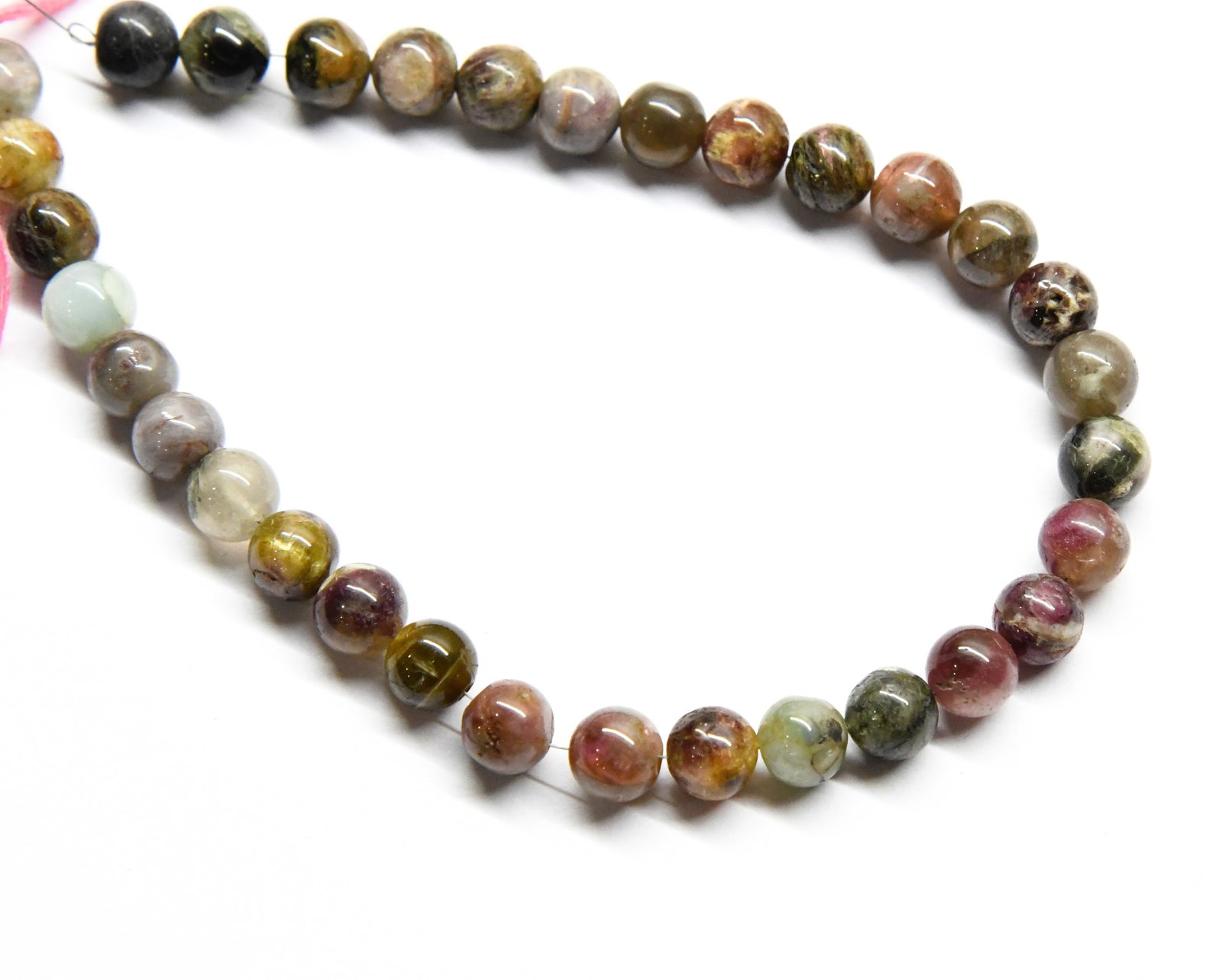 NATURAL MULTI TOURMALINE BEADS ROUND 9 MM, 11" STRAND: These are natural, earth mined and hand crafted with precision. Stone: Multi Tourmaline, Stone Shape: Round, Stone Size: 9 mm, Weight: approx. 185 carats. The photographs are generally enlarged to sho