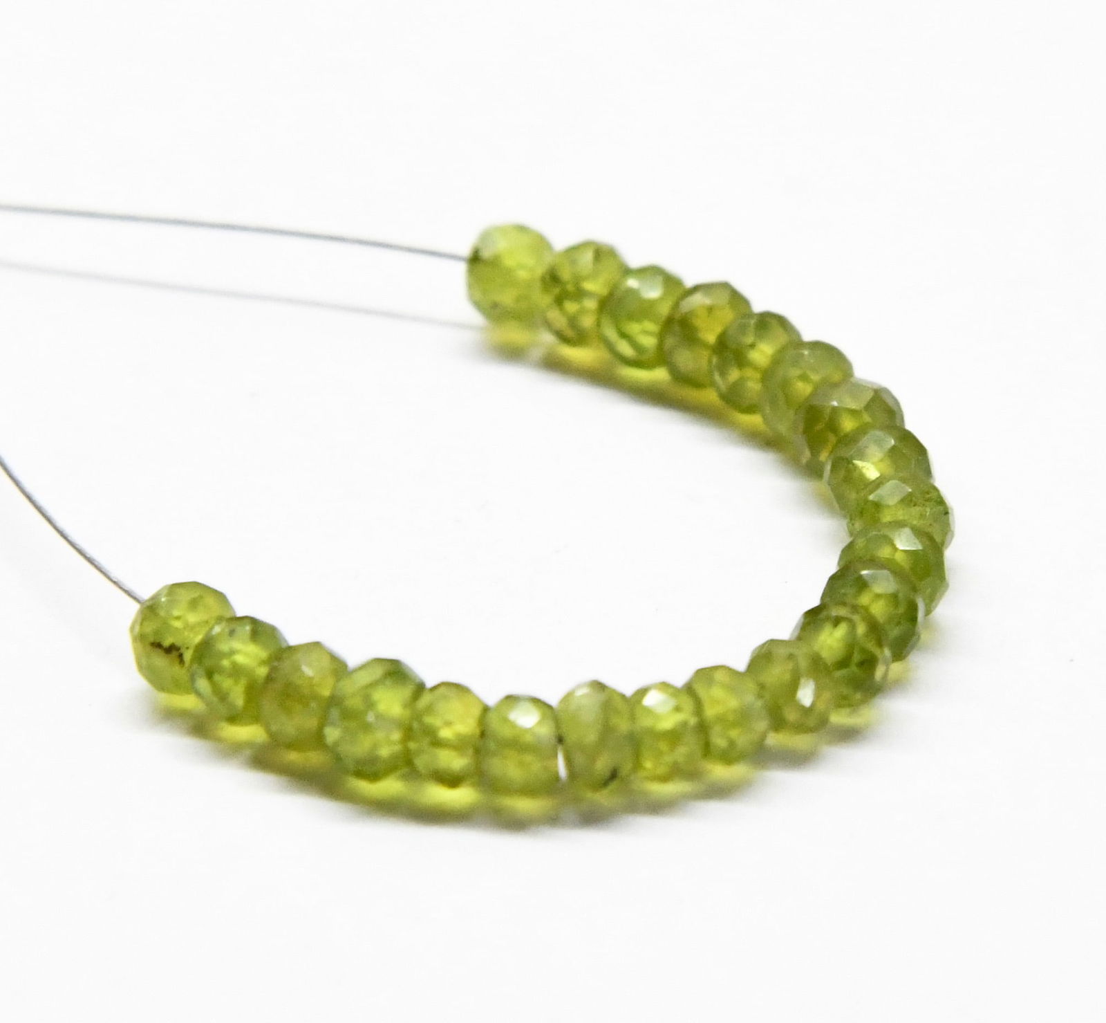 NATURAL PERIDOT BEADS FACETED RONDELLE 4 MM, 22 PCS: These are natural, earth mined and hand crafted with precision. Stone: Peridot, Stone Shape: Faceted Rondelle, Stone Size: 4 mm, Width: 2.5 - 3 mm, Weight: approx. 9 carats. The photographs are genera