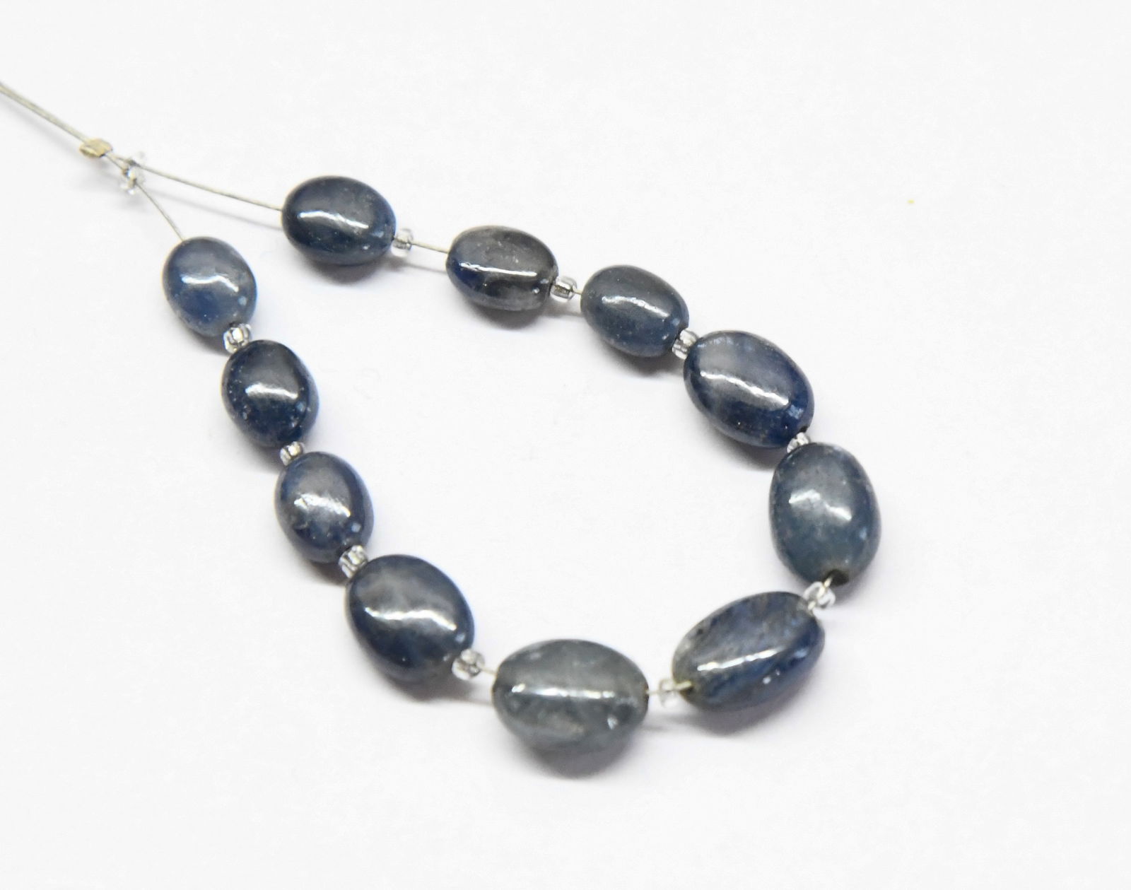 NATURAL BLUE SAPPHIRE BEADS OVAL 5X6 - 7X9 MM 11 PCS (3 TASSELS): These are natural, earth mined and hand crafted with precision. Stone: Blue Sapphire, Stone Shape: Oval, Stone Size: 5x6 - 7x9 mm, Width: 3 - 5 mm, Weight: approx. 23.33 carats. The photographs are en