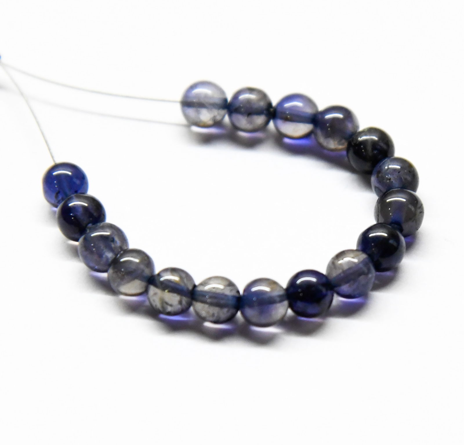 NATURAL IOLITE BEADS ROUND 5 MM 17 PCS (2 TASSELS): These are natural, earth mined and hand crafted with precision. Stone: Iolite, Shape: Round, Size: 5 mm, Weight: approx. 16 carats. The photographs are enlarged to show the clarity and cuts more accur