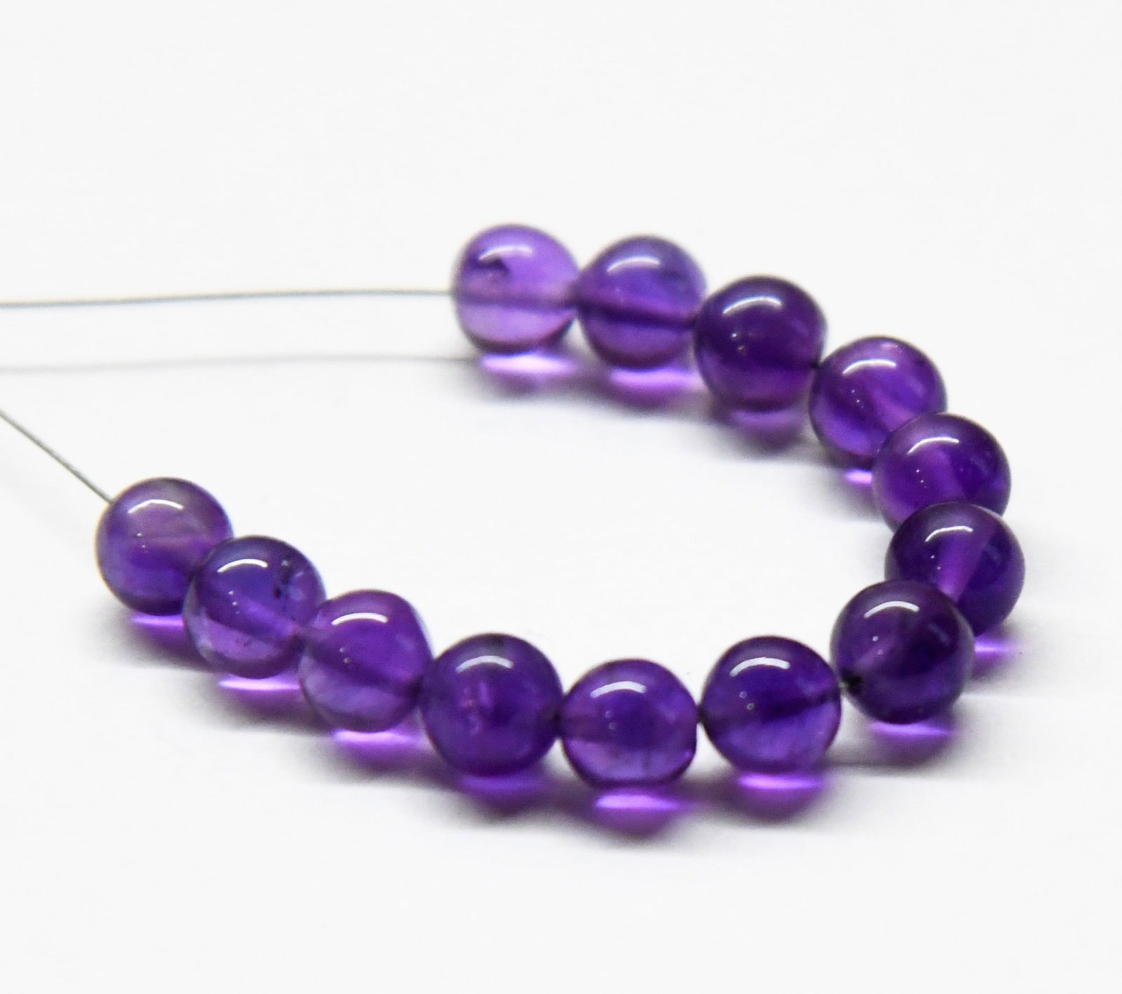 NATURAL AMETHYST BEADS ROUND 5.5 MM 13 PCS (2 TASSELS): These are natural, earth mined and hand crafted with precision. Stone: Amethyst, Shape: Round, Size: 5.5 mm, Weight: approx. 16 carats. The photographs are enlarged to show the clarity and cuts more a