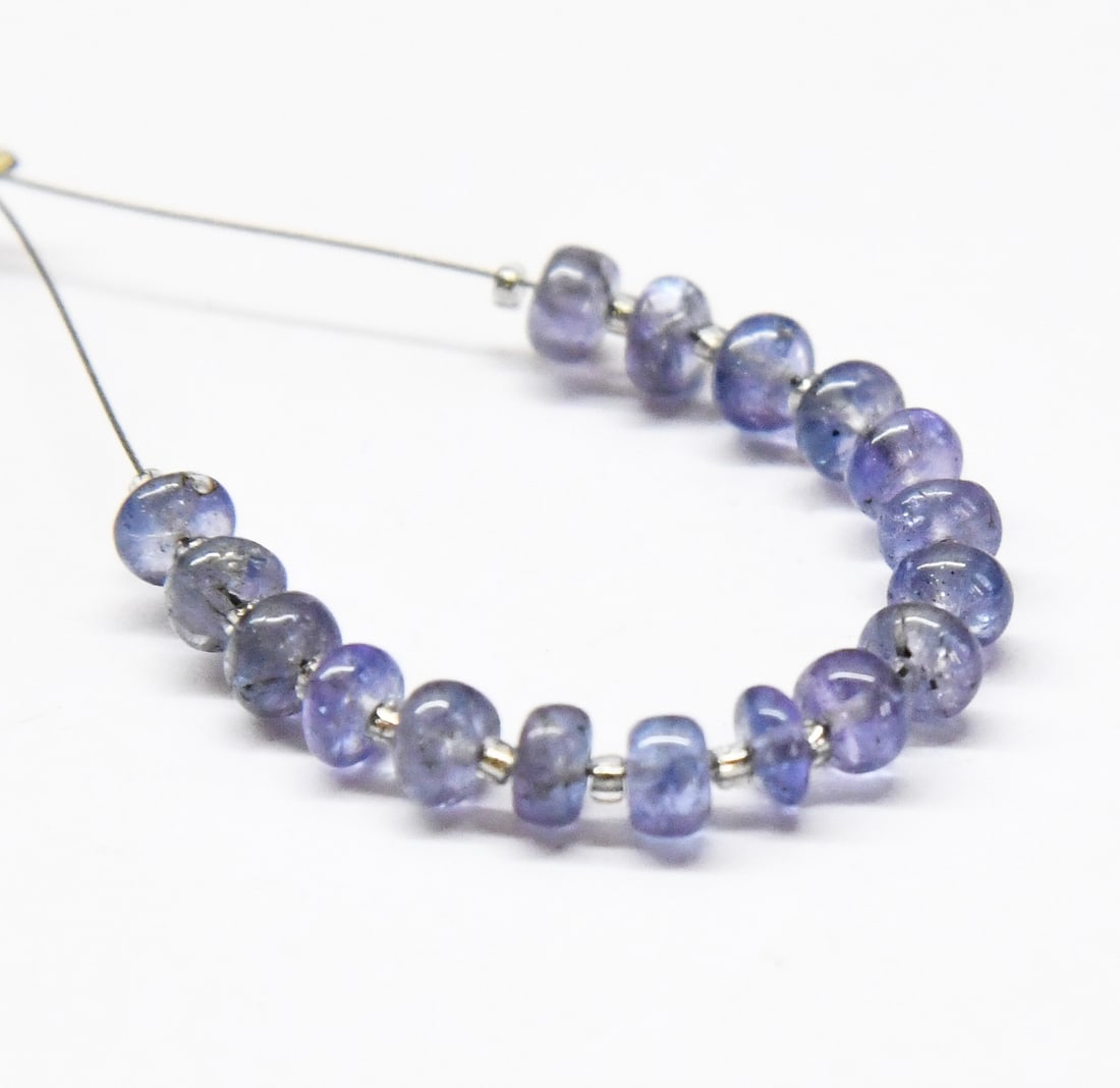 NATURAL TANZANITE BEADS RONDELLE 4 - 4.5 MM 17 PCS (2 TASSELS): These are natural, earth mined and hand crafted with precision. Stone: Tanzanite, Shape: Rondelle, Size: 4 - 4.5 mm, Width: 2 - 3 mm, Weight: approx. 9 carats. The photographs are enlarged to show the
