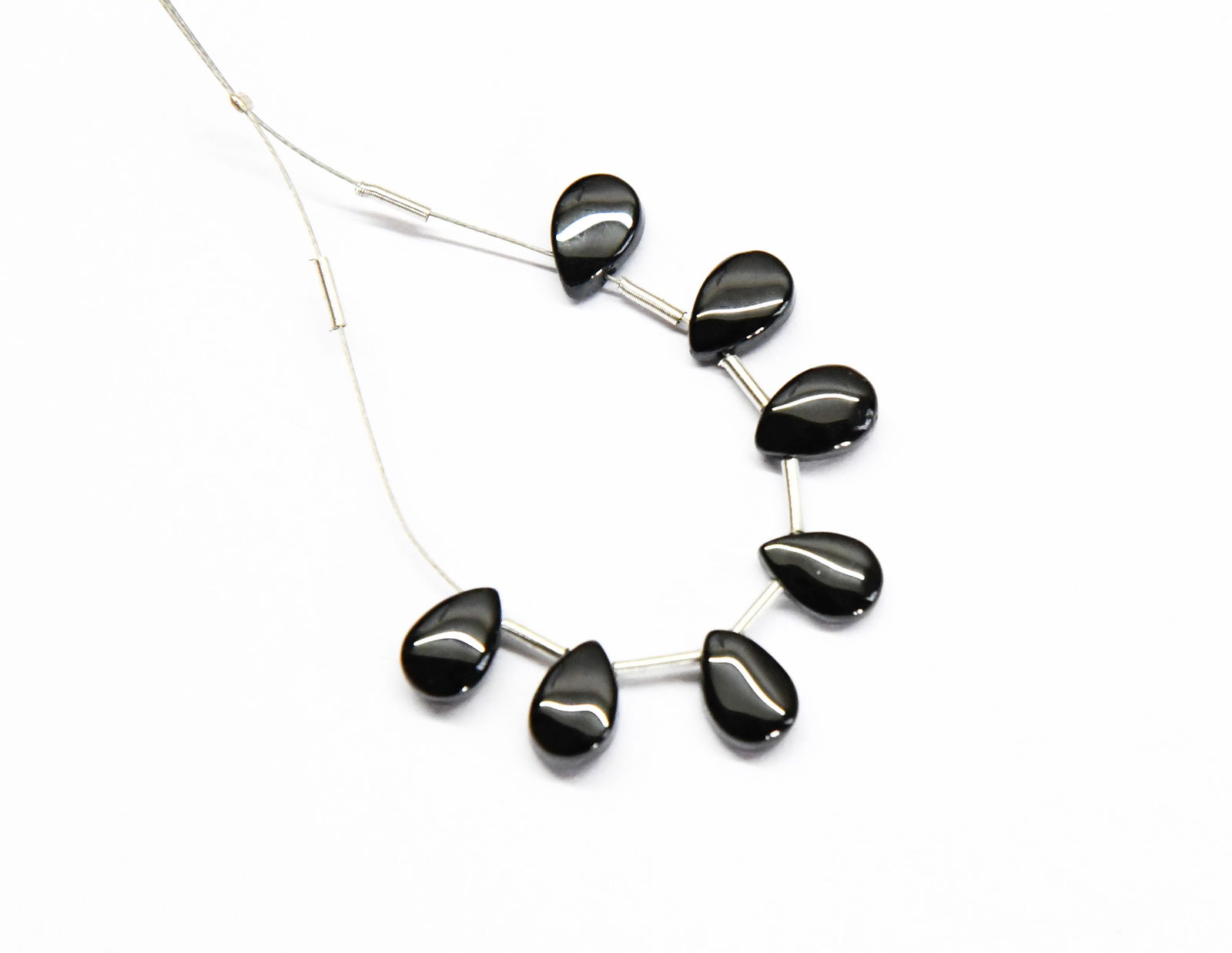 NATURAL BLACK SPINEL BEADS PEAR 5.5X8 MM 7 PCS (2 TASSELS): These are natural, earth mined and hand crafted with precision. Stone: Black Spinel, Shape: Pear, Size: 5.5x8 mm, Width: 3 - 3.5 mm, Weight: approx. 12 carats. The photographs are enlarged to show the