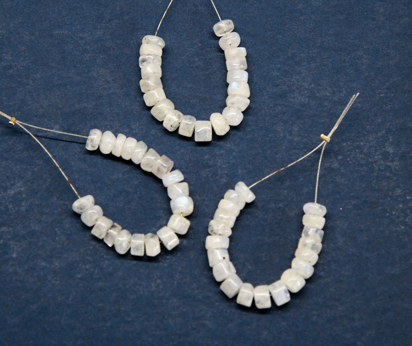 NATURAL RAINBOW MOONSTONE BEADS TYRE 5.5 MM 19 PCS (3 TASSELS): These are natural, earth mined and hand crafted with precision. Stone: Rainbow Moonstone, Shape: Tyre, Size: 5.5 mm, Width: 2 - 3 mm, Weight: approx. 17 carats. The photographs are enlarged to show th