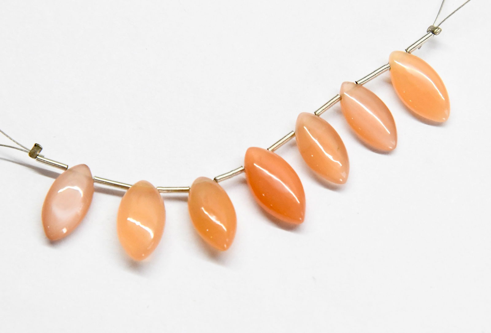 NATURAL PEACH MOONSTONE BEADS MARQUISE 6X12 - 7X14 MM 7 PCS: These are natural, earth mined and hand crafted with precision. Stone: Peach Moonstone, Stone Shape: Marquise, Stone Size: 6.5x12.5 - 7x14 mm, Width: 3 - 4 mm, Weight: approx. 18 carats. The photograp