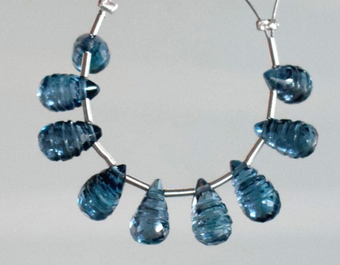 NATURAL BLUE TOPAZ BEADS FACETED CARVED BRIOLETTE 4.5X7.5 - 4.5X8MM 9 PCS: These are natural, earth mined and hand crafted with precision. Stone: London Blue Topaz, Stone Shape: Carved Briolette, Stone Size: 4.5x7.5 - 4.5x8 mm, Weight: approx. 15 carats. The photographs are