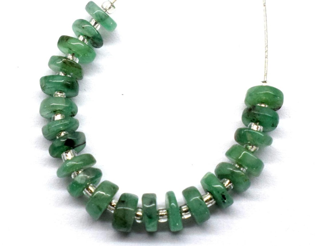 NATURAL EMERALD BEADS TYRE 4.5 MM 21 PCS (2 TASSELS): These are natural, earth mined and hand crafted with precision. Stone: Emerald, Stone Shape: Tyre, Stone Size: 4.5 mm, Width: 1 - 2 mm, Weight: approx. 8 carats. The photographs are enlarged to show t