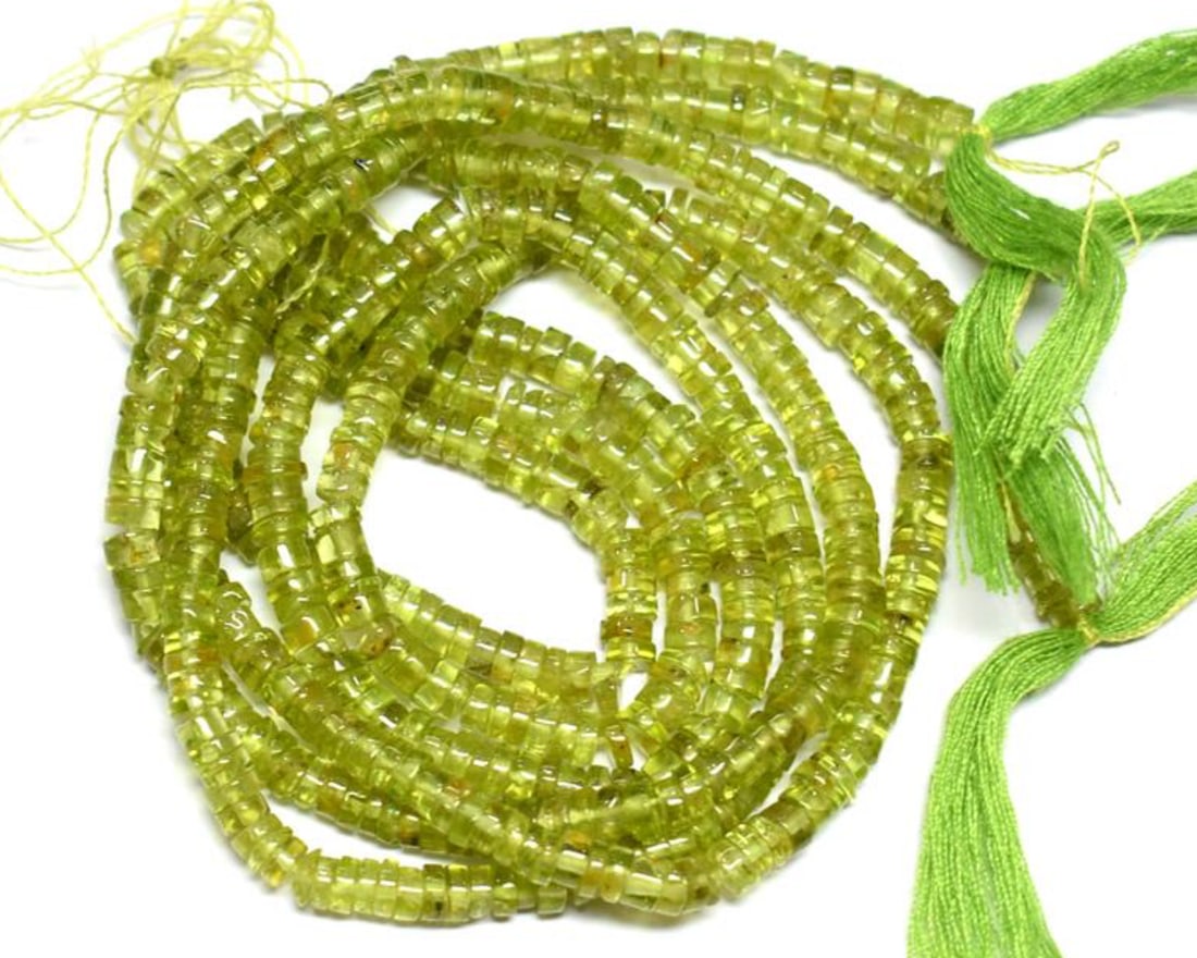 13.5" STRAND NATURAL PERIDOT BEADS TYRE 4 MM 1 LINE: These are natural, earth mined and hand crafted with precision. Stone: Peridot, Stone Shape: Tyre, Stone Size: 4 mm, Width: 1.5 - 2 mm, Weight: approx. 72 carats. The photographs are enlarged to show