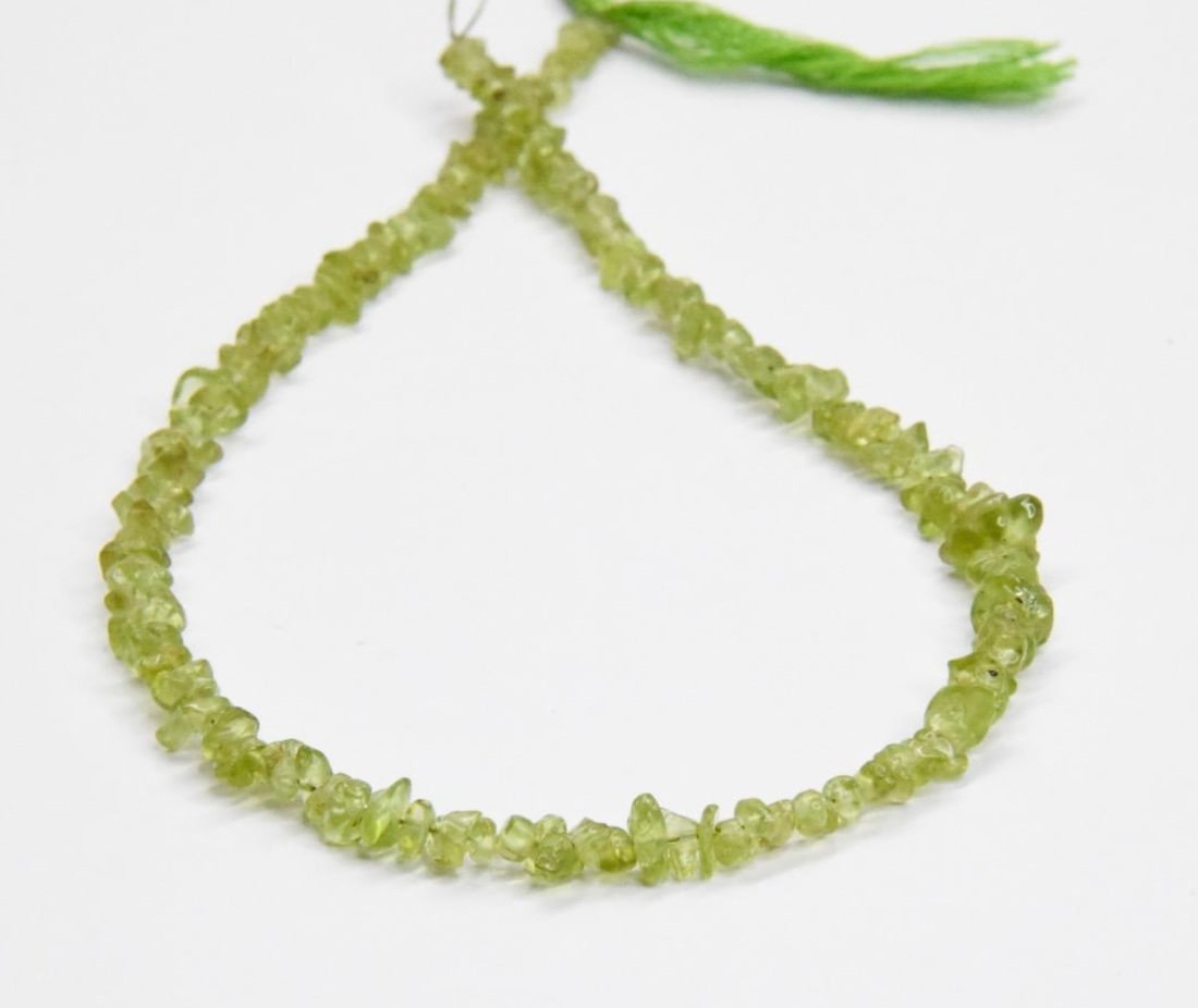 NATURAL PERIDOT BEADS CHIPS 2X3 - 4X6 MM, 11.5" STRAND: These are natural, earth mined and hand crafted with precision. Stone: Peridot, Stone Shape: Chips, Stone Size: 2.5x3 - 4x6 mm, Width: 1 - 3 mm, Weight: 41 carats. The photographs are generally enlarg