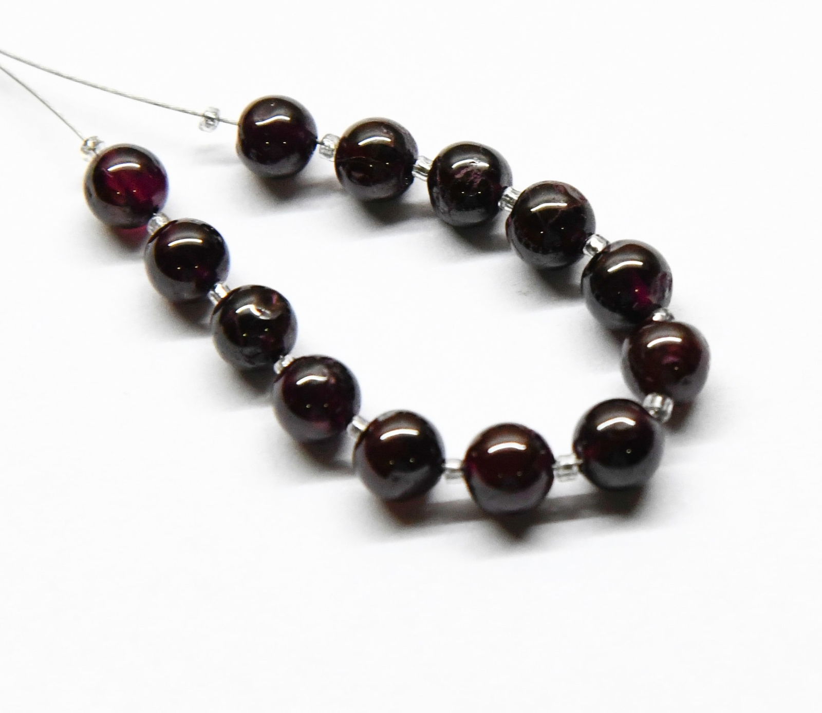 NATURAL GARNET BEADS ROUND 5.5 MM 13 PCS (2 TASSELS): These are natural, earth mined and hand crafted with precision. Stone: Garnet, Stone Shape: Round, Stone Size: 5.5 mm, Weight: approx. 24 carats. The photographs are generally enlarged to show the cla