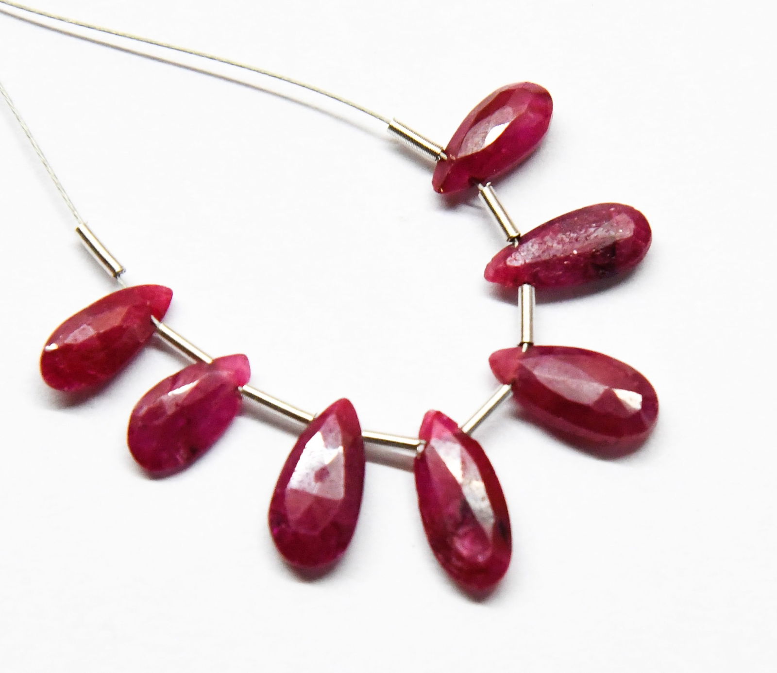 NATURAL RUBY BEADS FACETED PEAR 4X9 - 5X12 MM, 7 PCS (3 TASSELS): These are natural, earth mined and hand crafted with precision. Stone: Ruby, Stone Shape: Faceted Pear, Stone Size: 4x9 - 5.5x12 mm, Width: 2.5 - 3 mm, Weight: approx. 9.62 carats. The photographs are