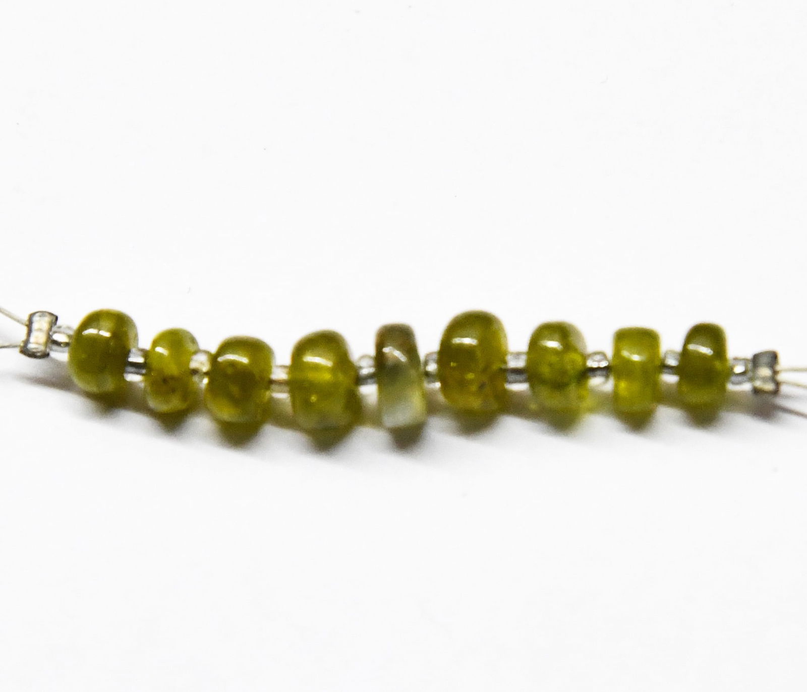 NATURAL CHRYSOBERYL BEADS RONDELLE 4 - 5 MM, 9 PCS: These are natural, earth mined and hand crafted with precision. Stone: Chrysoberyl, Stone Shape: Rondelle, Stone Size: 4 - 5 mm, Width: 2 - 3 mm, Weight: approx. 5.7 carats. The photographs are genera
