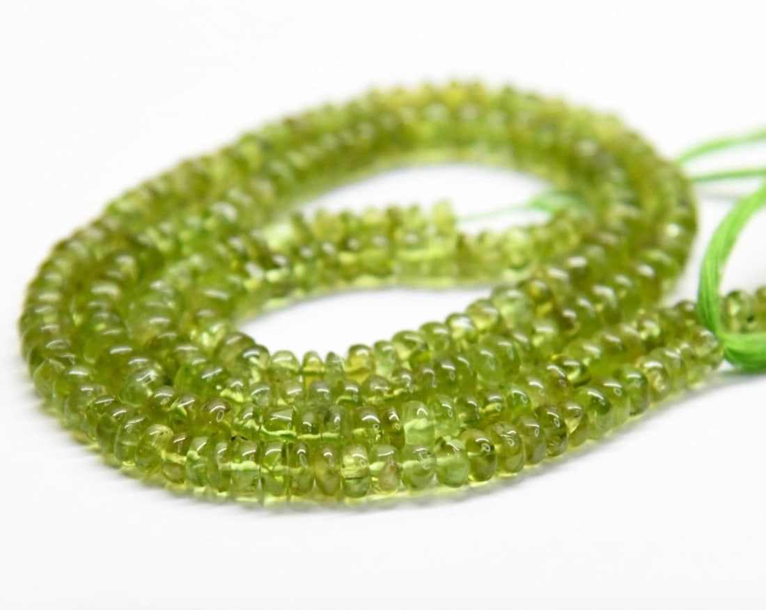 NATURAL PERIDOT BEADS RONDELLE 5 - 6 MM, 12" STRAND: These are natural, earth mined and hand crafted with precision. Stone: Peridot, Stone Shape: Rondelle, Stone Size: 5 - 6 mm, Width: 2 - 3.5 mm, Weight: approx. 104 carats. The photographs are generall